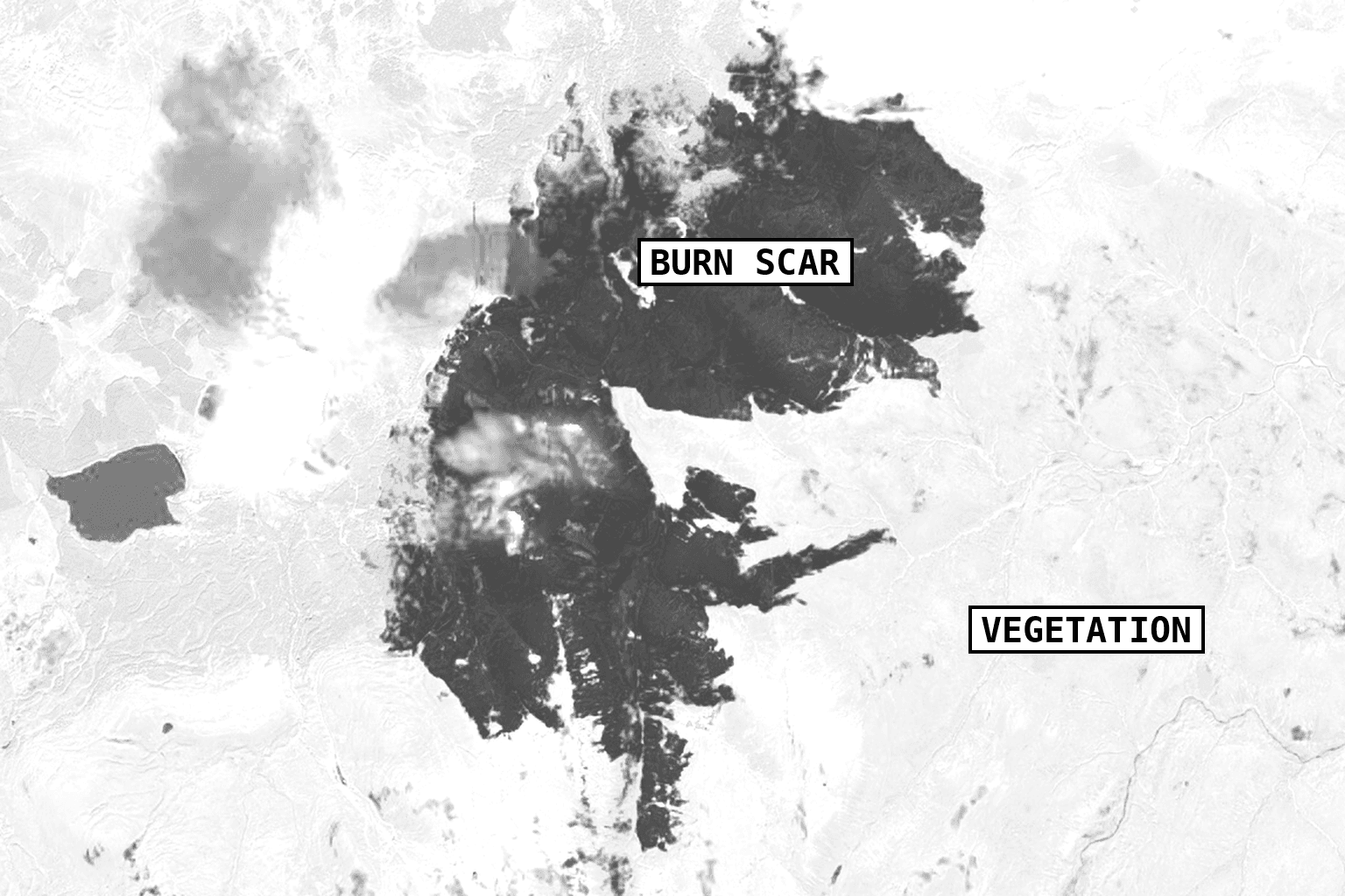 Sentinel-2 shortwave-infrared view of a wildfire burn scar, shown dark against surrounding vegetation